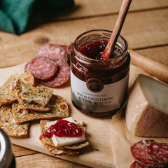 Pot de cerises à grappes cueillies dans la forêt nordique par Gourmet sauvage sur un plateau de fromage et de charcuteries. 