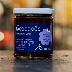 Pot en verre contenant une tartinade de petits fruits zéro déchet à partir de fruits rescapés dans les épicerie avec une étiquette bleu et un fond flouté