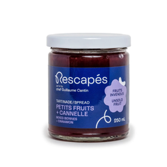 Pot en verre contenant une tartinade de petits fruits et à la  cannelle.zéro déchet à partir de fruits rescapés dans les épicerie avec une étiquette bleu et un fond blanc
