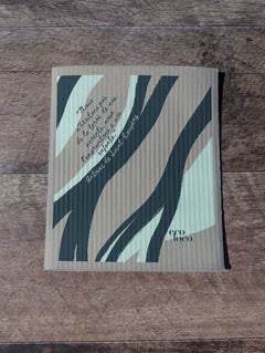 Chiffon suédois ou essuie-tout réutilisable avec un motif de vague et une écriture d'antoine de st-Exupery sur un fond Gris