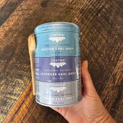 Coffret cadeau de thé Justea dans une main. 3 saveurs