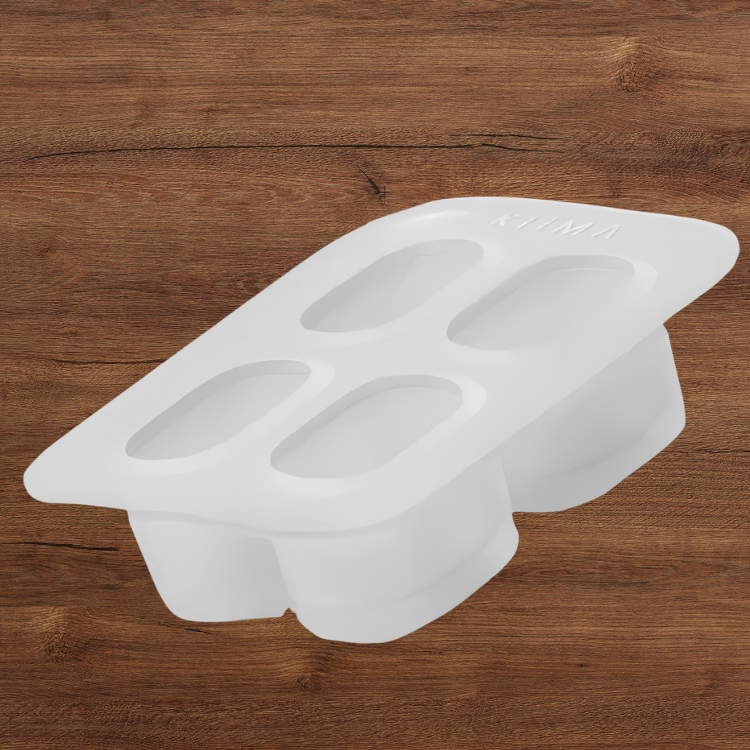 Un moule en silicone pour recharge de baume avec 4 cavités et un arrière-plan de bois. 